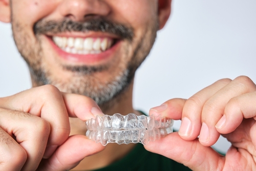 Closeup,Man,Hand,Holding,Transparent,Retainer,With,Unrecognizable,Bearded,Man