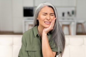 Troubled,Mature,50s,Woman,With,Gray-hair,Feels,Strong,Toothache,,Holding